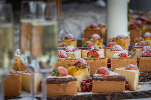 einzelne Käsekuchenstücke mit Erdbeeren auf einem Holzbrett