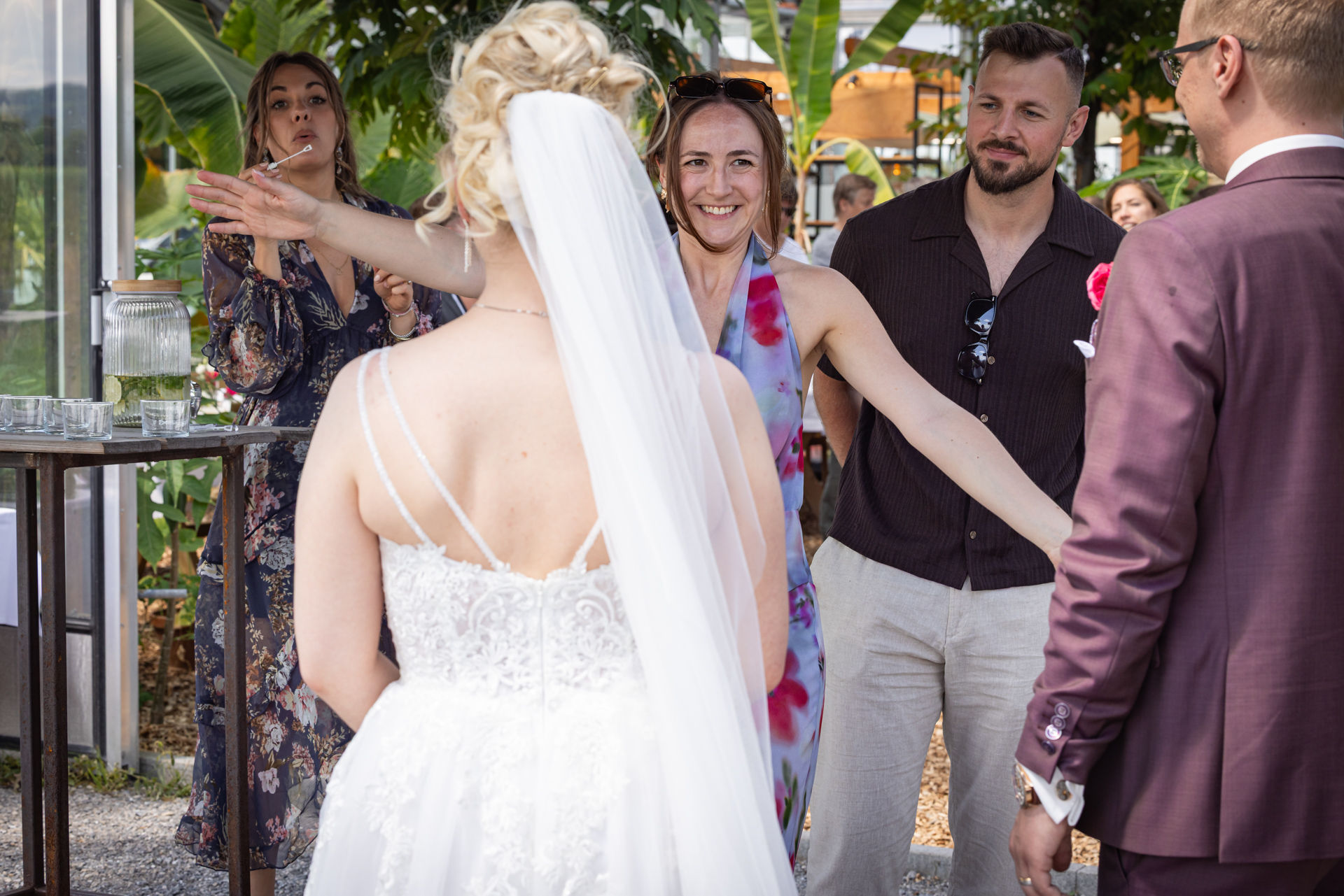 sektempfang-hochzeit-tropenhaus-weihenlinden, Gast breitet Arme aus, geht auf Braut zu