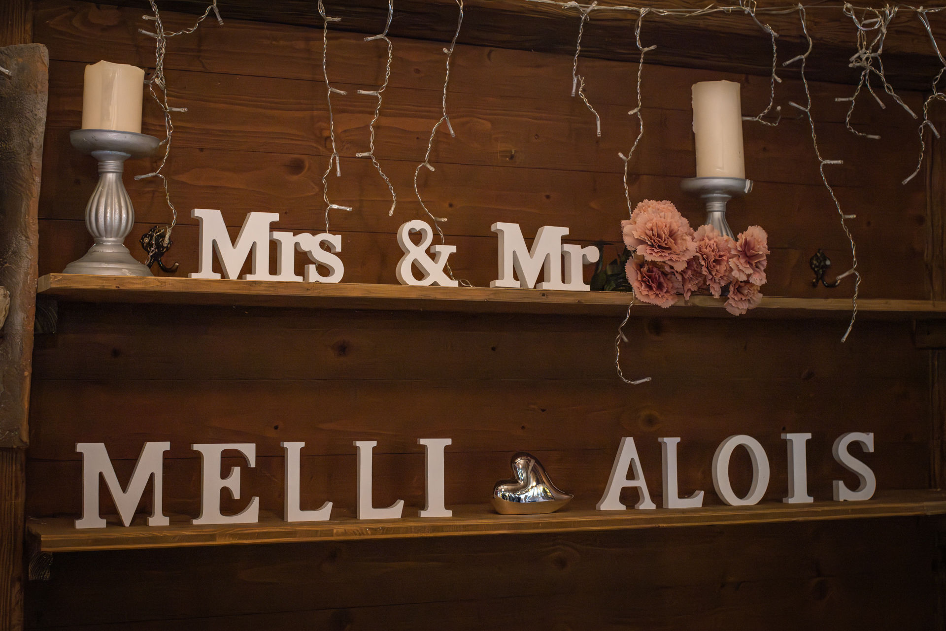 Schriftzug Mrs & Mr auf Holzwand, zwei Kerzen