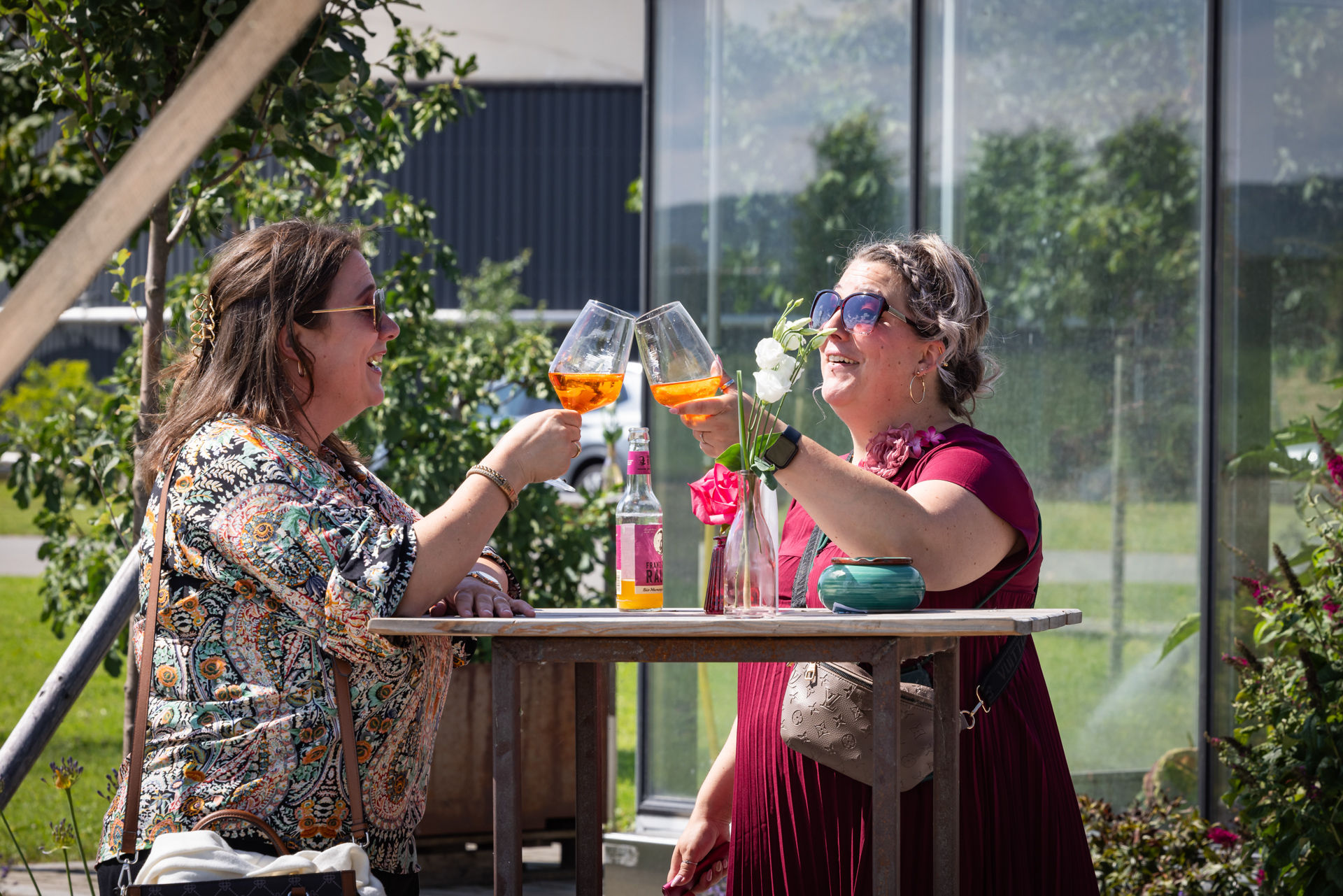 sektempfang-hochzeit-tropenhaus-weihenlinden, zwei Frauen stoßen mit Aperol an