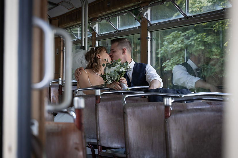 Hochzeitspaar in einer Tram mit Brautstrauß