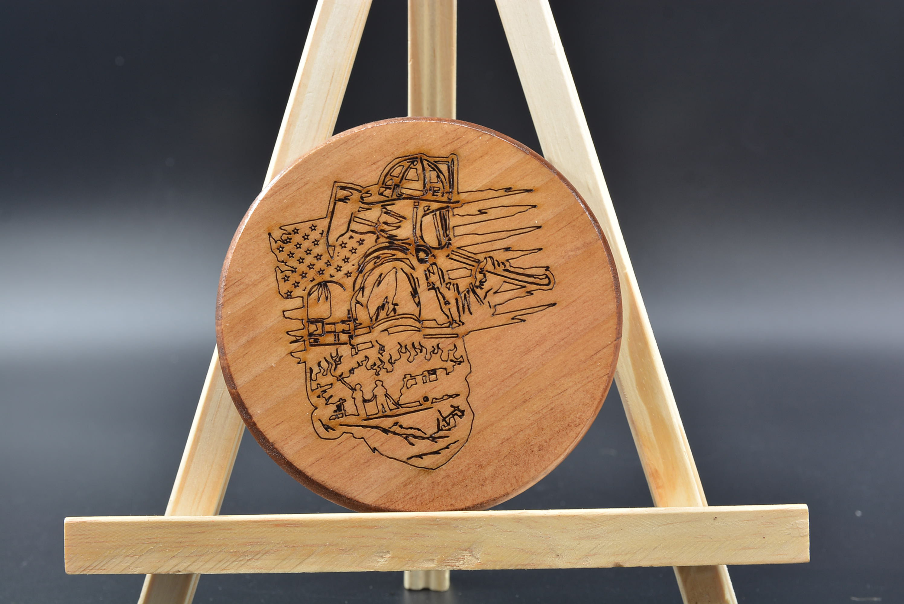 4-inch round wooden coaster with detailed firefighter‑themed engraved design.