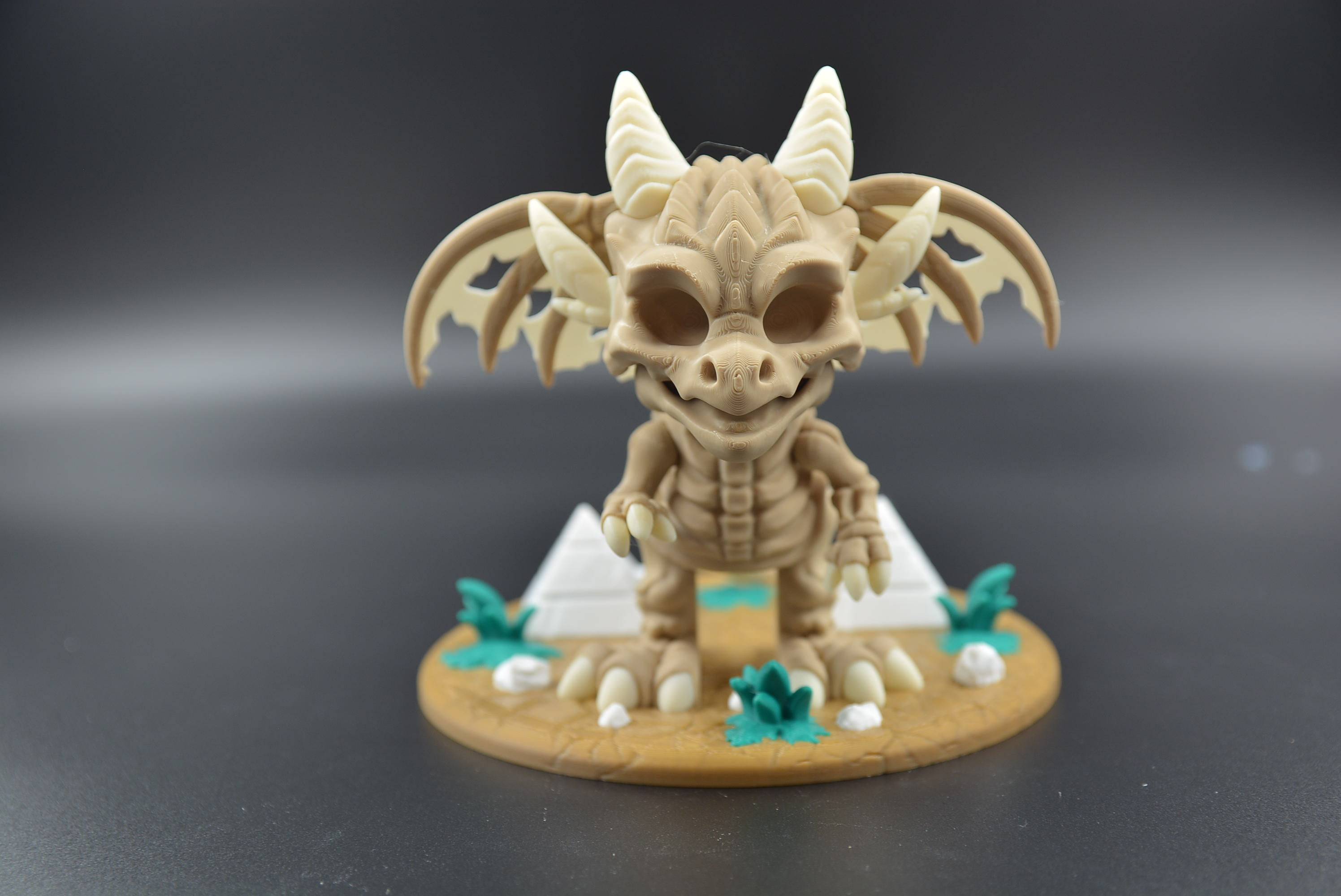 Bone Wing skeletal flexi dragon displayed on a removable bone‑pile base with skulls and bones