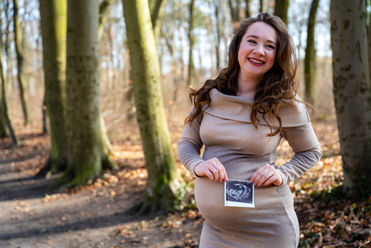 Schwangere Frau im Wald mit Ultraschallbild, Schwangerschaft. Glückliche Frau im Herbstwald