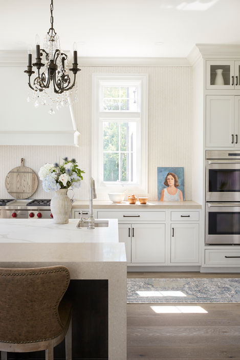 Custom kitchen styling with white cabinetry, layered decor, and natural light