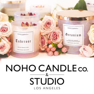beautiful handmade candles surrounded by flowers and the NOHO Candle logo