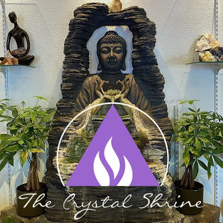 logo of the Crystal Shrine in front of a tranquil statue of Buddha