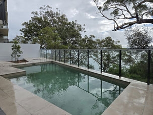 Coastal apartment landscape design in Nelson Bay featuring a swimming pool, native vegetation and water views