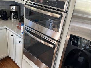 Modern kitchen with stainless steel double oven, coffee maker on white counter. Text: Appliance Repair, FIX UFA, website link.