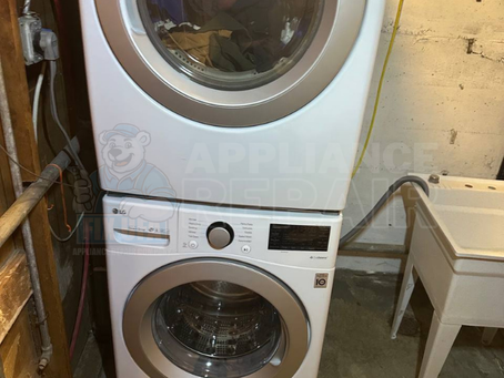 Stacked washer and dryer in a basement laundry room. "APPLIANCE REPAIR" text with logo. Website www.fixufa.com at bottom. Neutral tone.