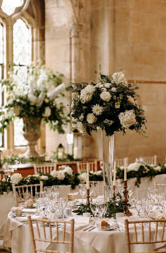 Floating floral displays above round wedding tables.