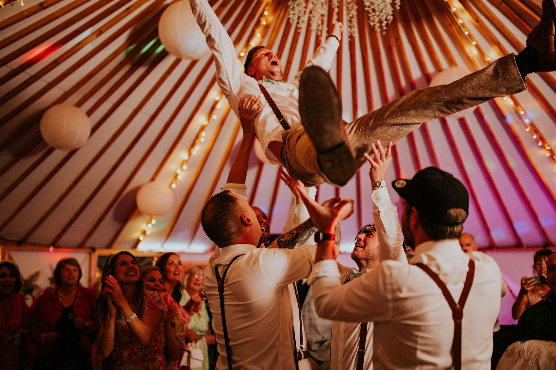Groom being thrown in the air on the dance floor 