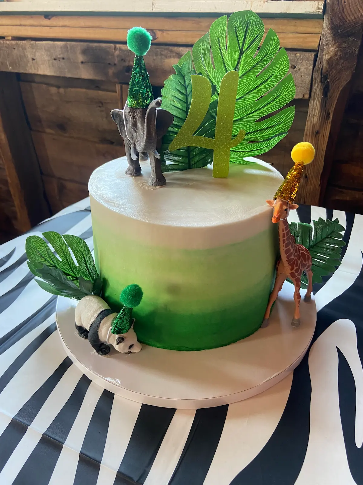 green and white jungle themed cake with a 2 on top
