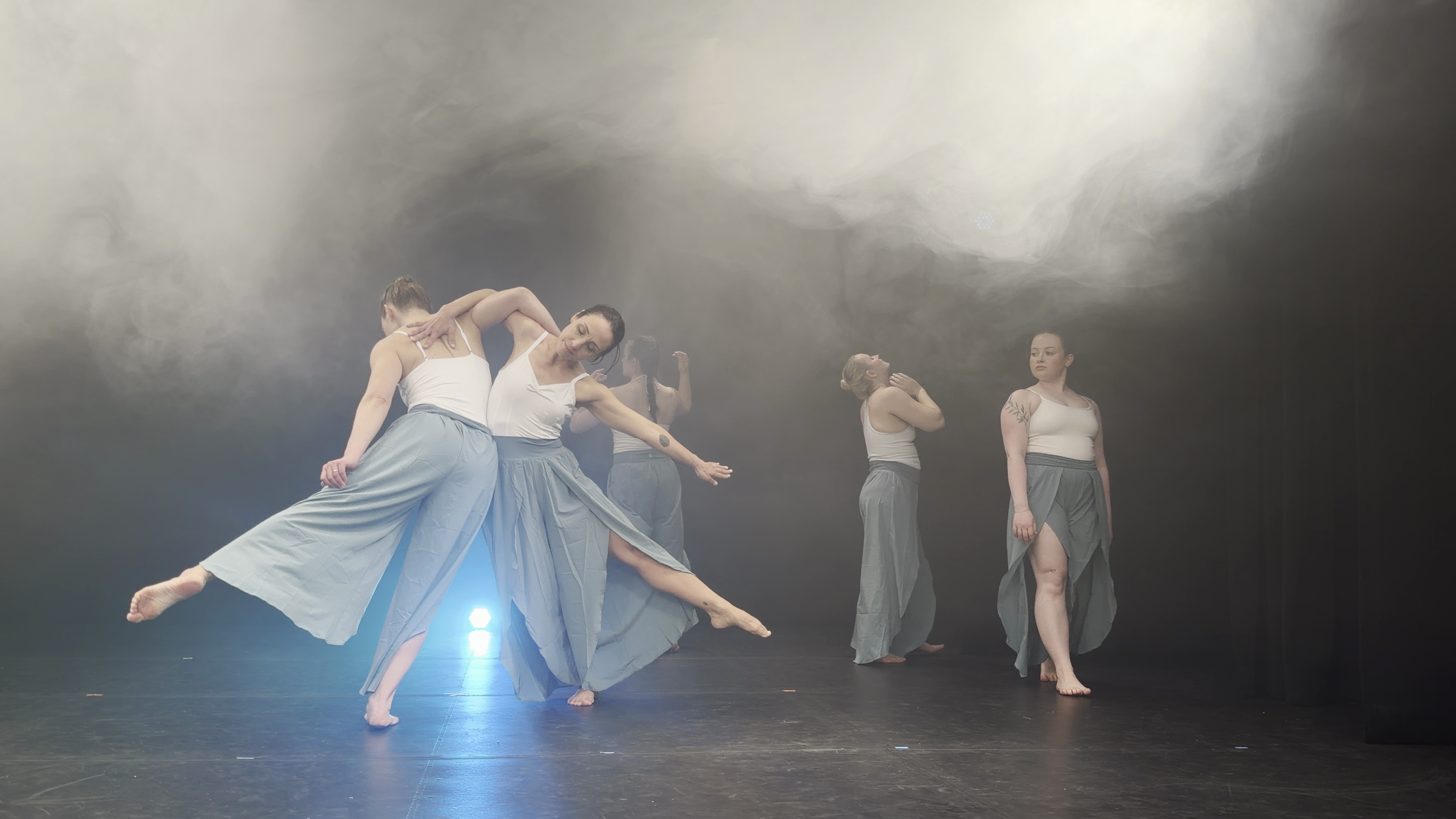 Dynamic light illuminating abstract movement in a dance studio setting.