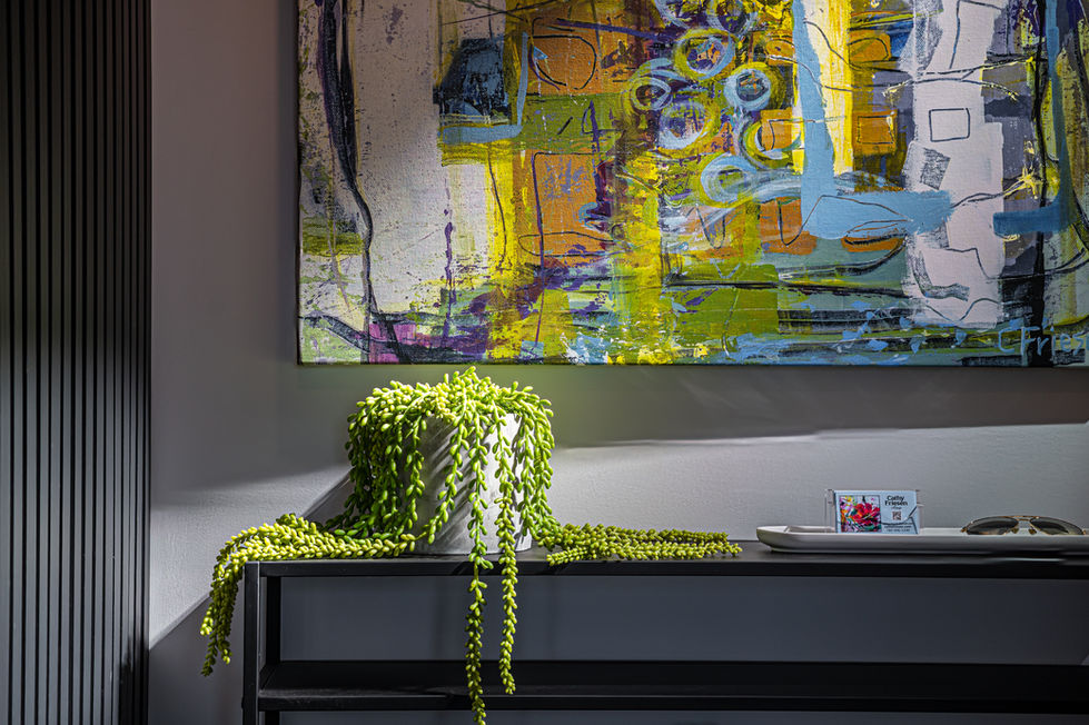 st albert show home with green modern abstract wall art above table with Cascading string of pearls plant on table below