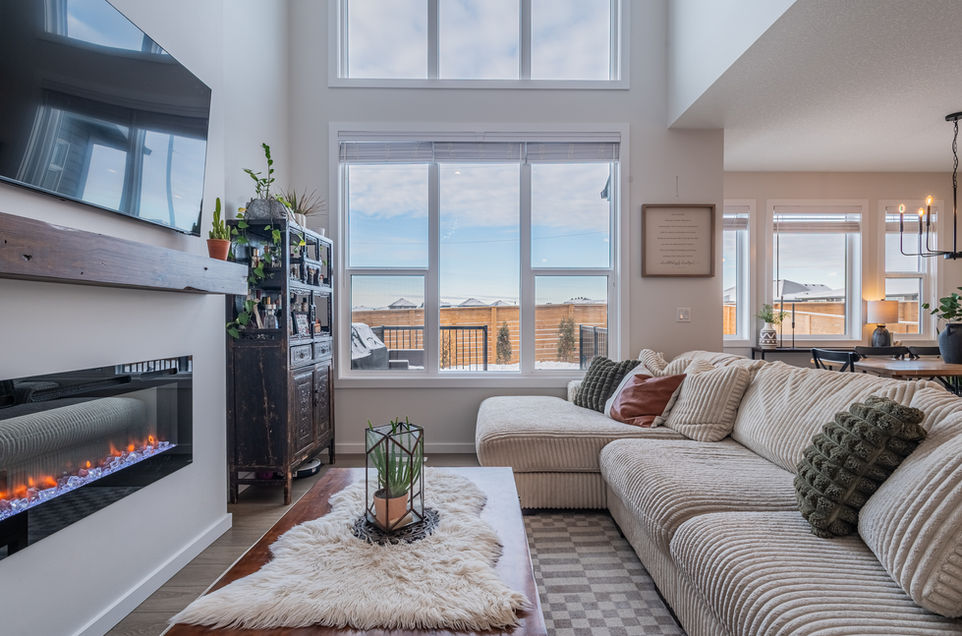 high ceiling , fireplace on the left, surrounded by white sofas st Albert real estate photography