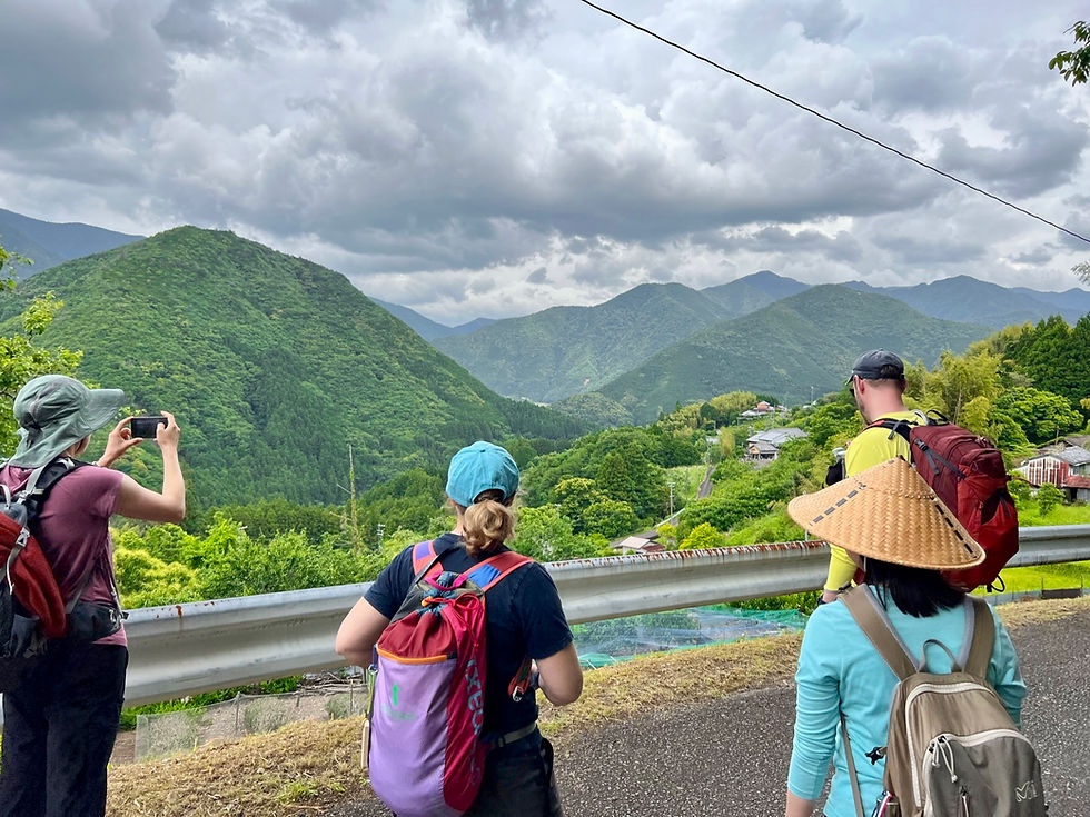 Travelers and a local guide on the Kumano Kodo trail, sharing a quiet moment during one of the best small group tours in Japan.