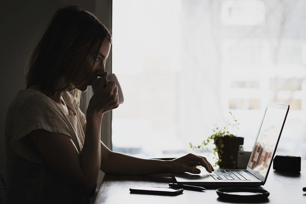 Woman drinking coffee while working