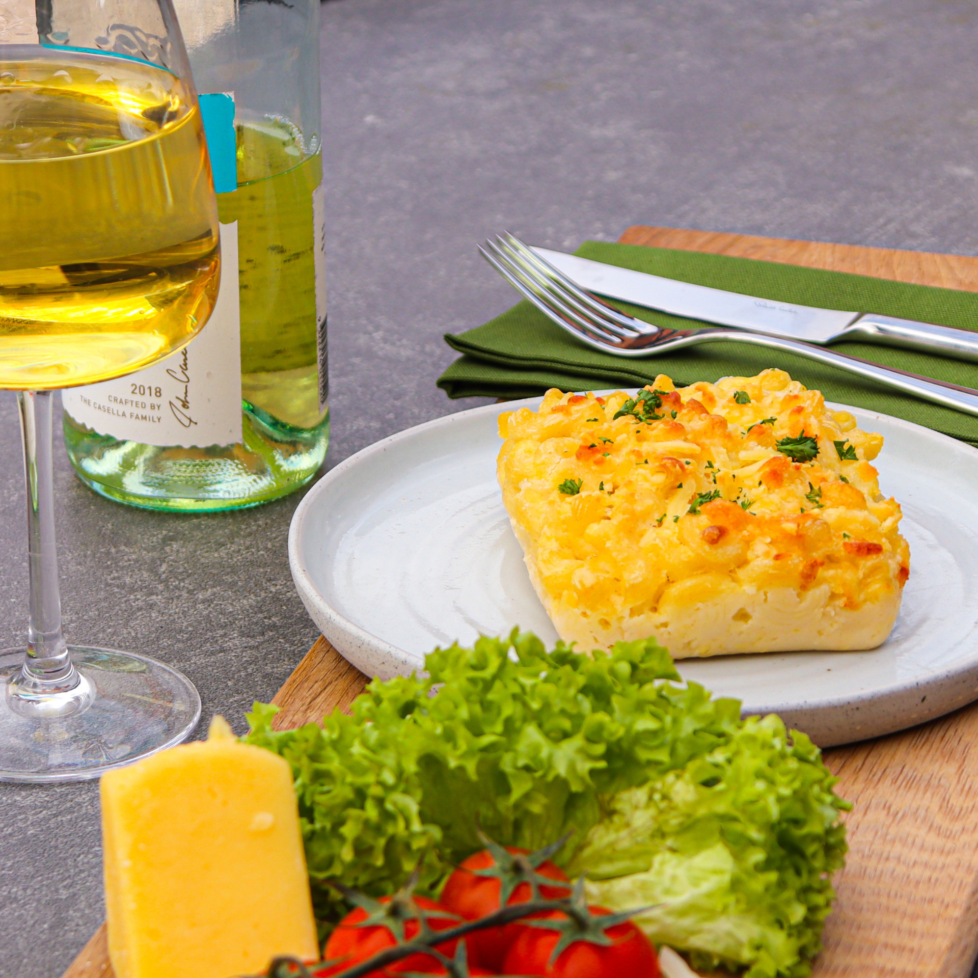 Sourced Meals Vegetarian Macaroni Cheese on a white plate with salad, cheese and white wine