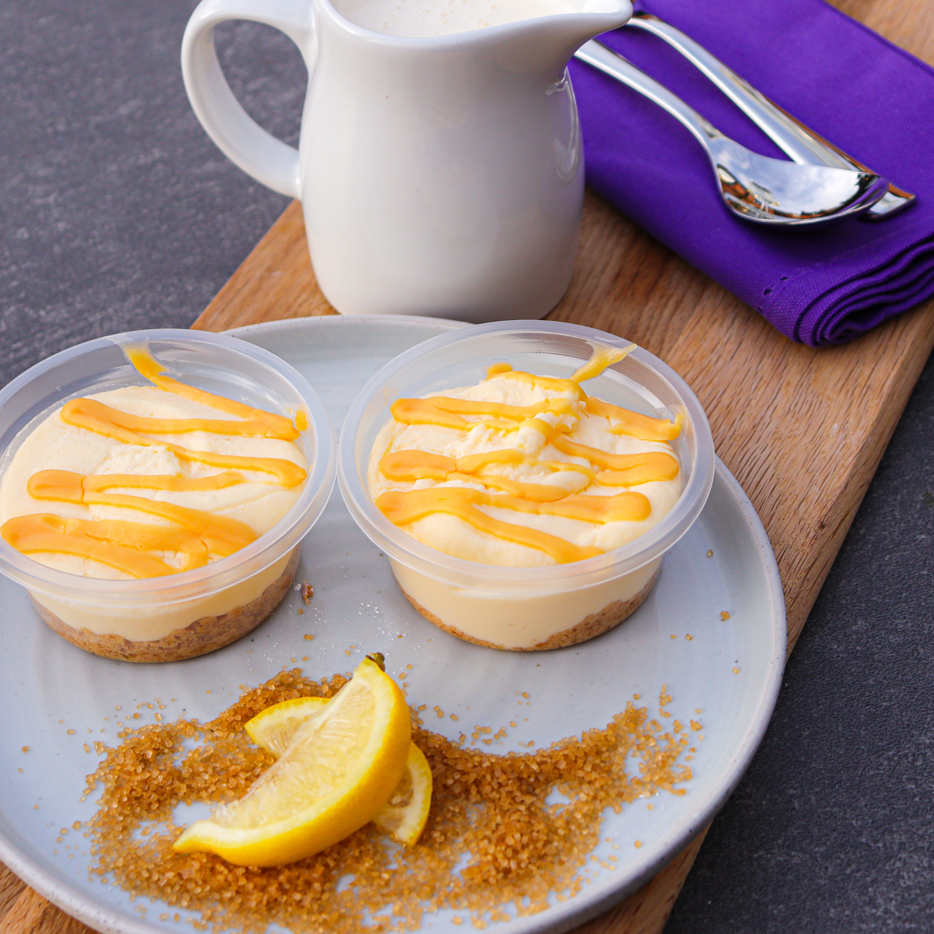 Lemon and lime cheesecakes with a lemon wedge and crumbled biscuit