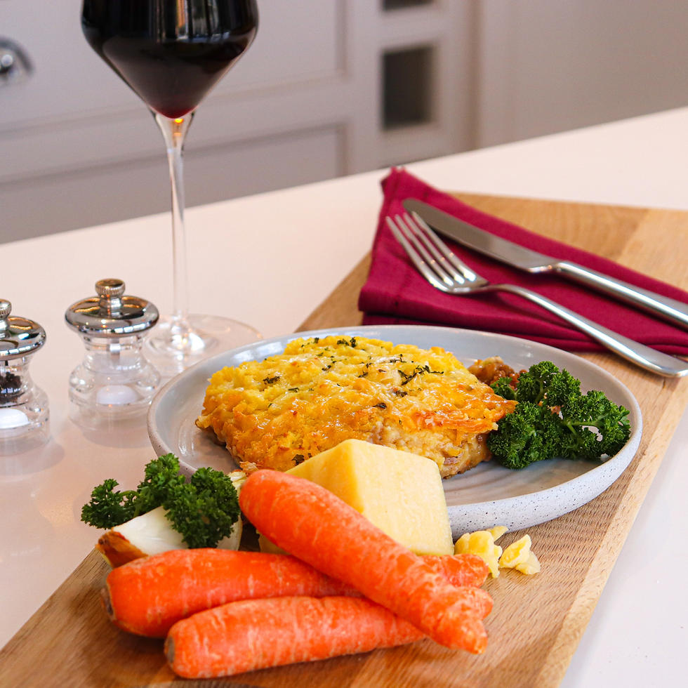 Cottage pie served with carrots, broccoli and a glass of red wine