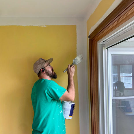 Man painting yellow walls
