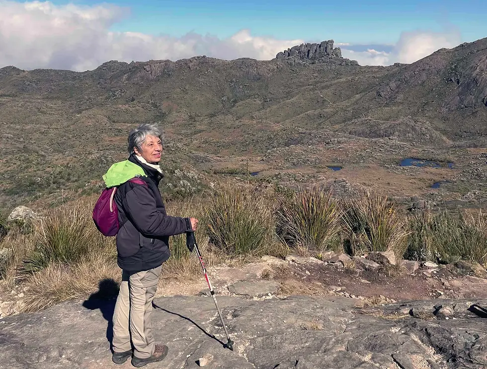 Mulher de 60+ com mochila em uma montanha