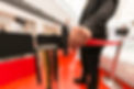 Security hand fastens a red tape closing the passage.jpg