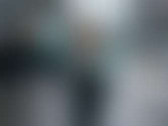 Woman walks on city street using smartphone, surrounded by digital notifications. Busy road and shops in the background. Urban tech vibe.