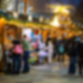 Atmospheric heritage-inspired outdoor Christmas market with warm glowing lights and traditional wooden cabins.