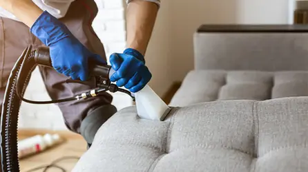 Man-professionally-cleaning-couch.webp