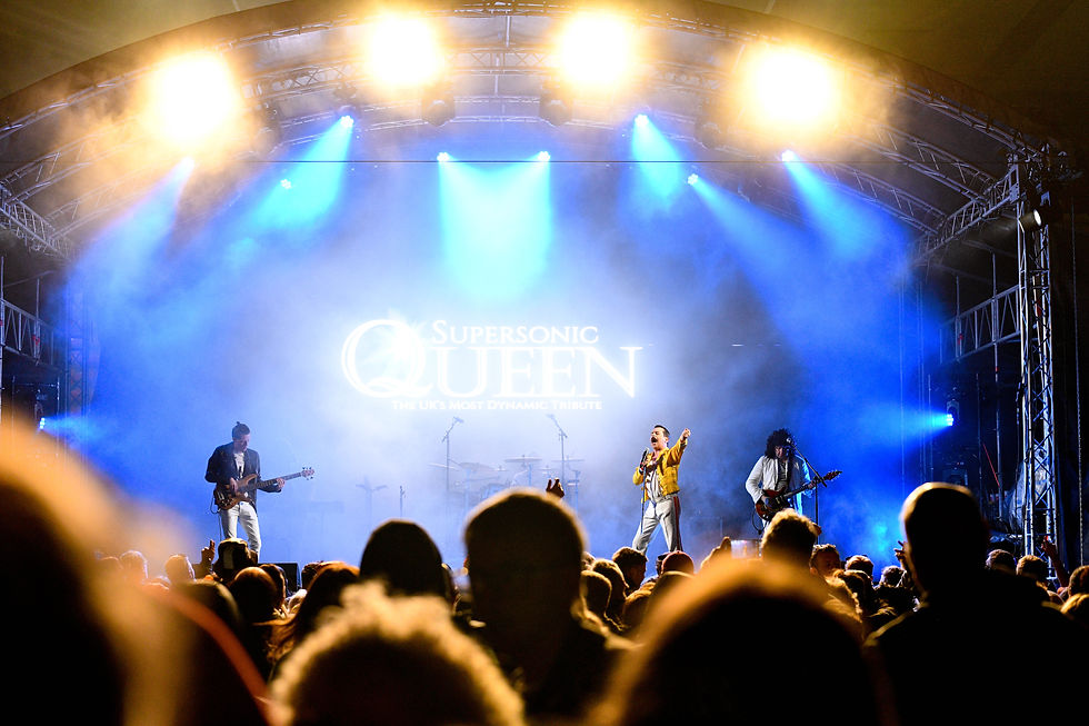 Eye-level view of a live rock band performing on stage with vibrant lighting