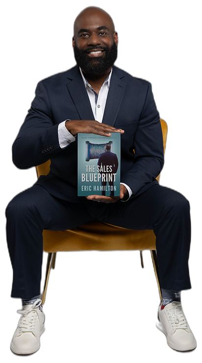 Eric Hamilton, speaker and author, seated and holding his book The Sales Blueprint.