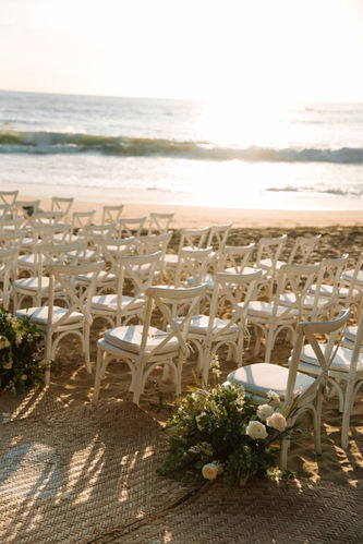Beach wedding ceremony setup, white chairs