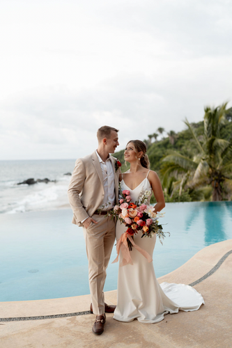 Happy couple by oceanfront pool; WEDDINGS