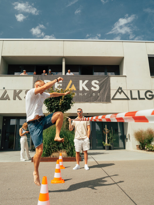 Sommerfest eines lokalen Fitnessstudios im Allgäu, Mann springt über eine Hürde, Challenge und Familiengefühl.
