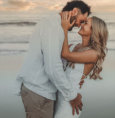Bride and groom embracing at golden hour on beach during Michigan wedding