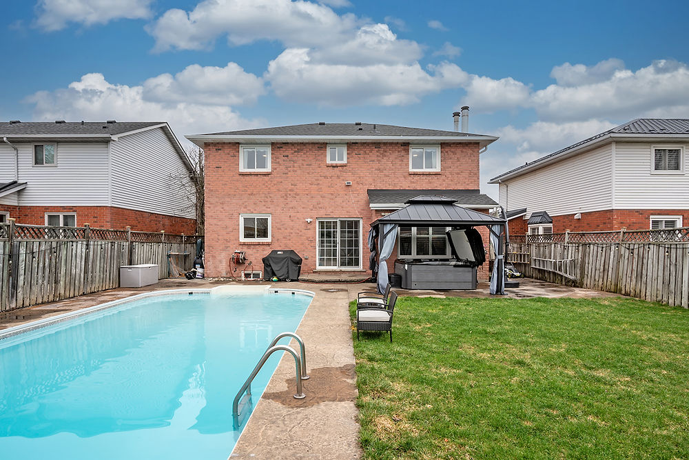 Rear view of brick house with pool and hot tub