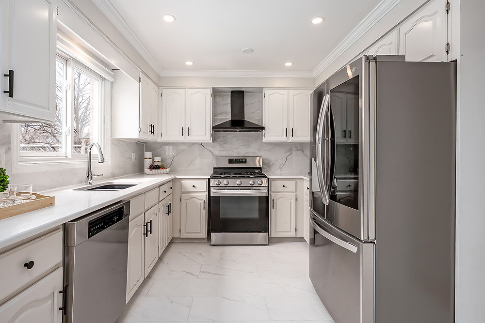 Modern kitchen with white cabinets and stainless steel appliances