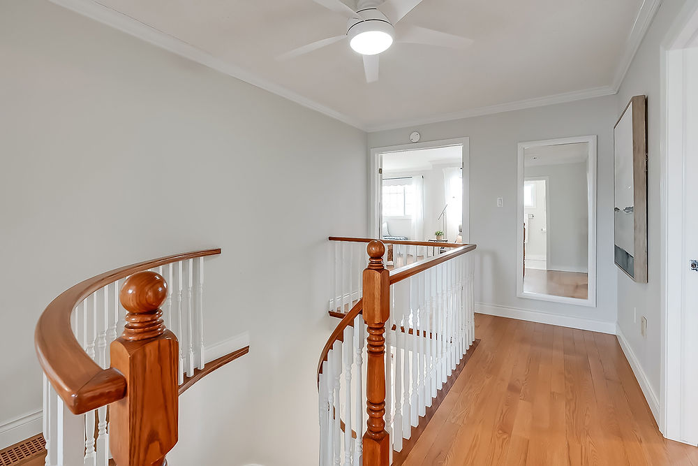 Hallway with wooden staircase and ceiling fan
