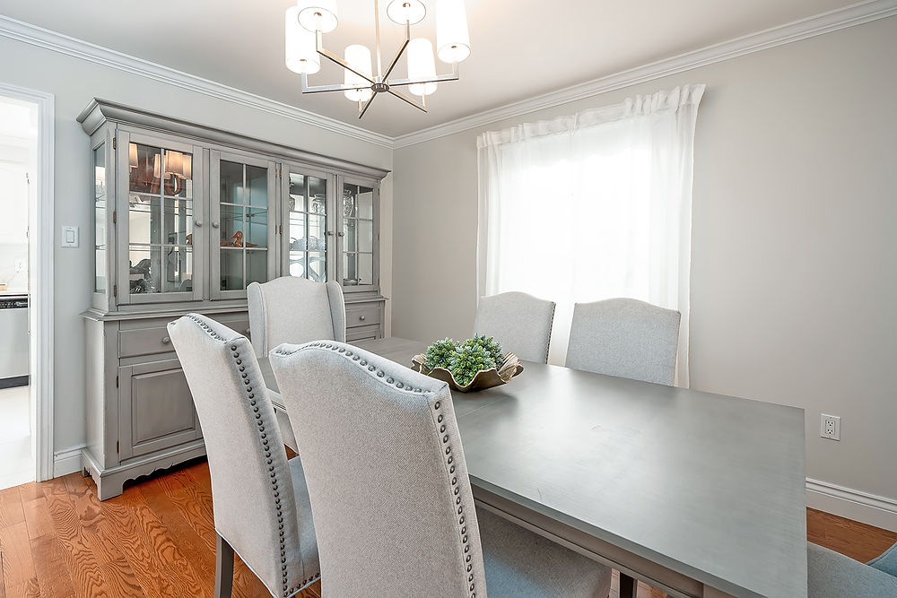 Dining room with grey table, chairs, and display cabinet