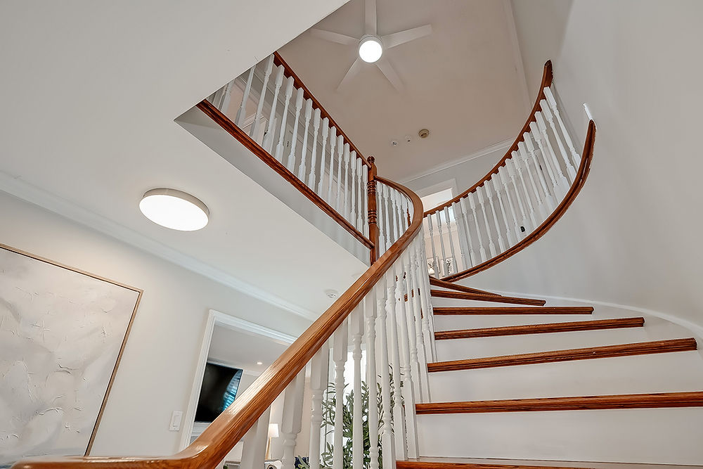 Elegant curving staircase with wood railing