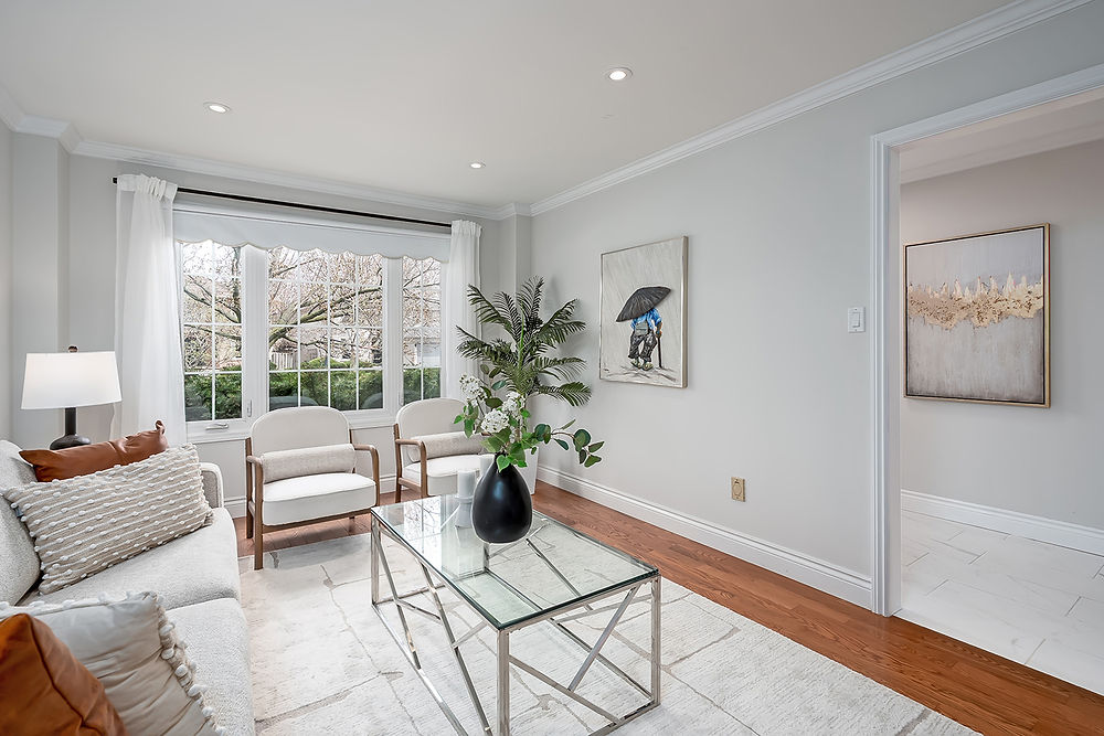 Living room with white sofa, coffee table, and bay window
