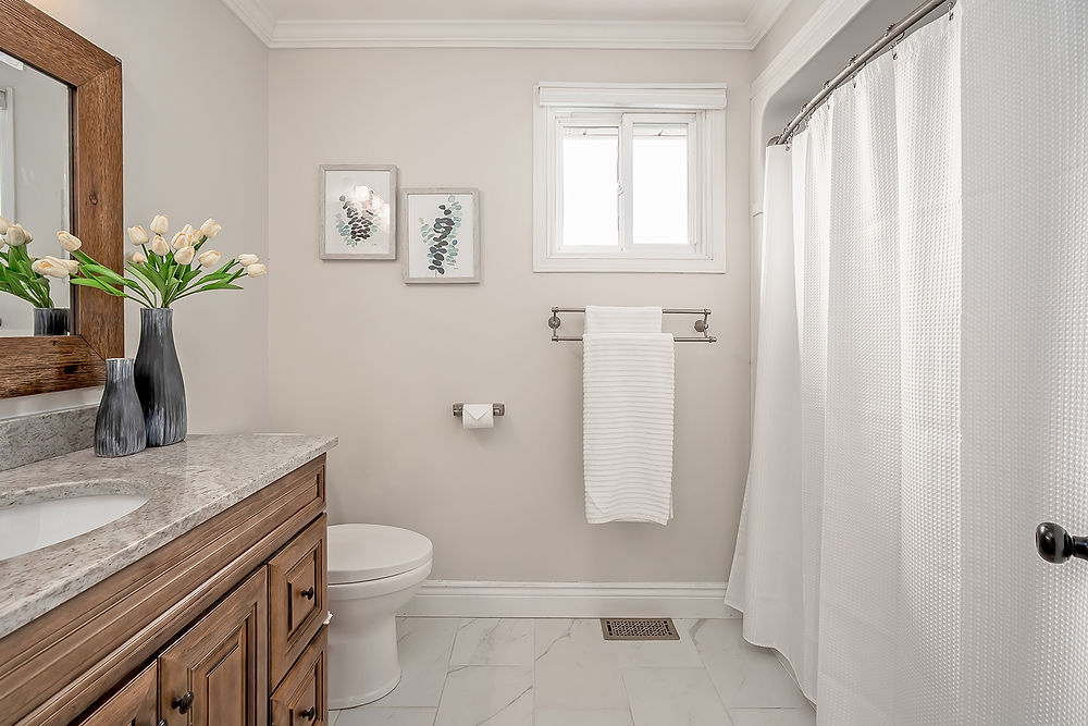 Bathroom with wooden vanity, toilet, and shower