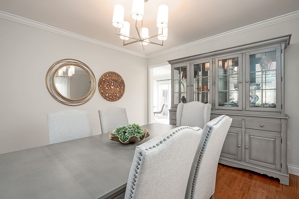 Dining room with gray table, upholstered chairs, and hutch