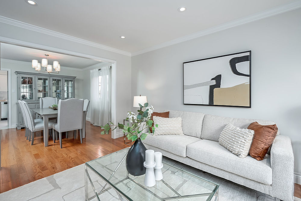 Modern living room with sofa, coffee table, and dining room view.