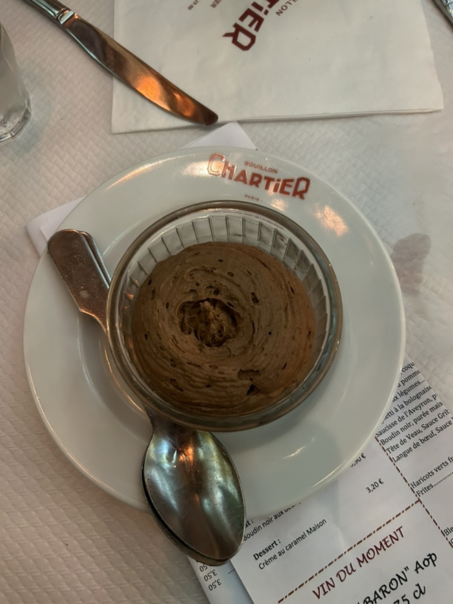 Baked dessert, crème caramel, in a glass bowl, on a white plate, with restaurant logo and menu.
