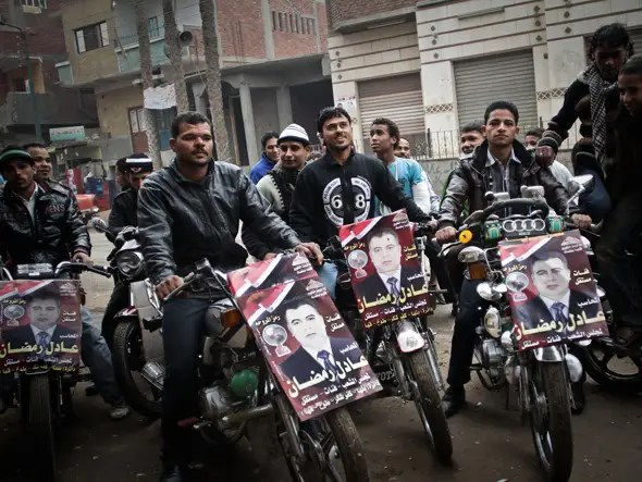 egyptian men on bikes with rally posters