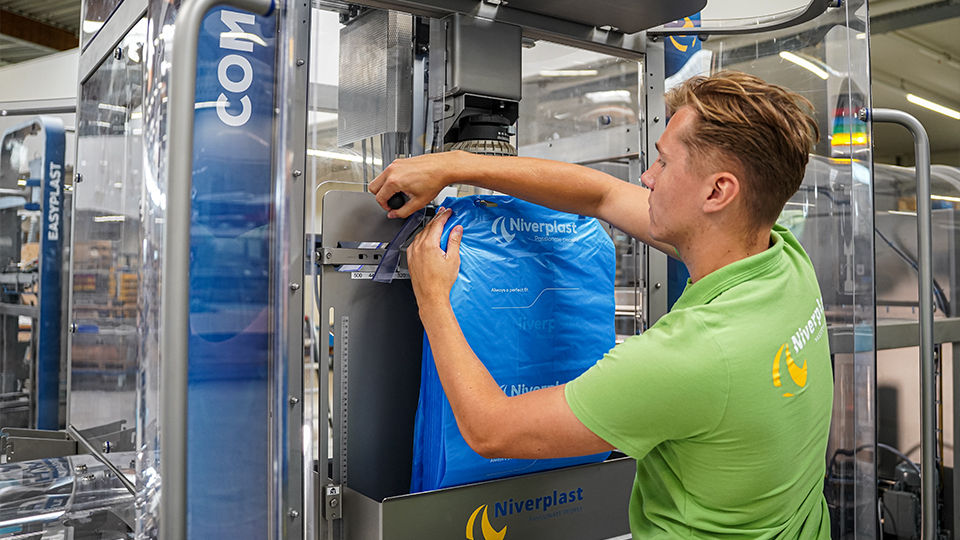 Man operating the E450 Bag Inserter machine.