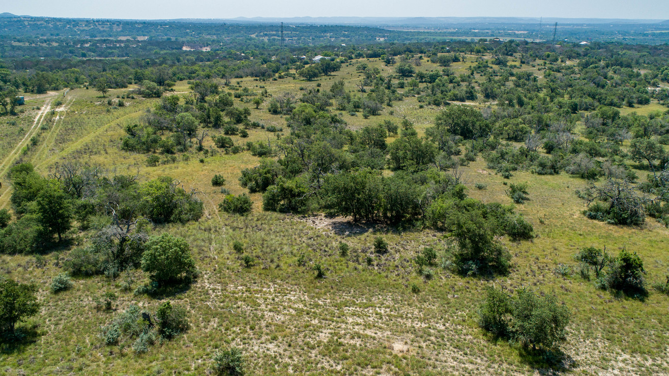 Aerial view of rolling hills and tree-covered land at Steel Creek Estates, TX